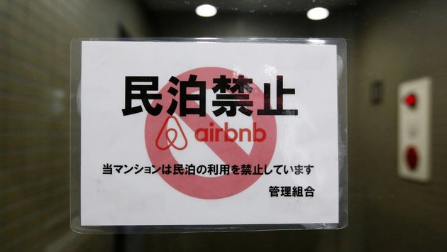 A sign at an apartment building in Tokyo displays a ban on Airbnb usage at the complex; © Reuters