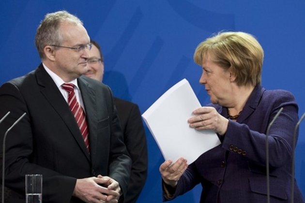 1Christoph Schmidt, Chef der Wirtschaftsweisen, übergibt das Jahresgutachten 013 an Bundeskanzlerin Angela Merkel. Foto: Agence France-Presse.