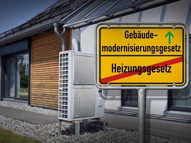 Straßenschild mit "Heizungsgesetz" durchgestrichen und darüber mit grünem Pfeil "Gebäudemodernisierungsgesetz"